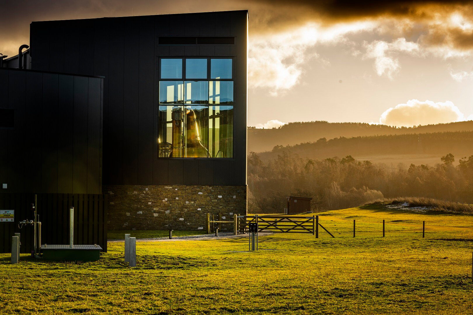 The Cairn Distillery with hillside view in the background